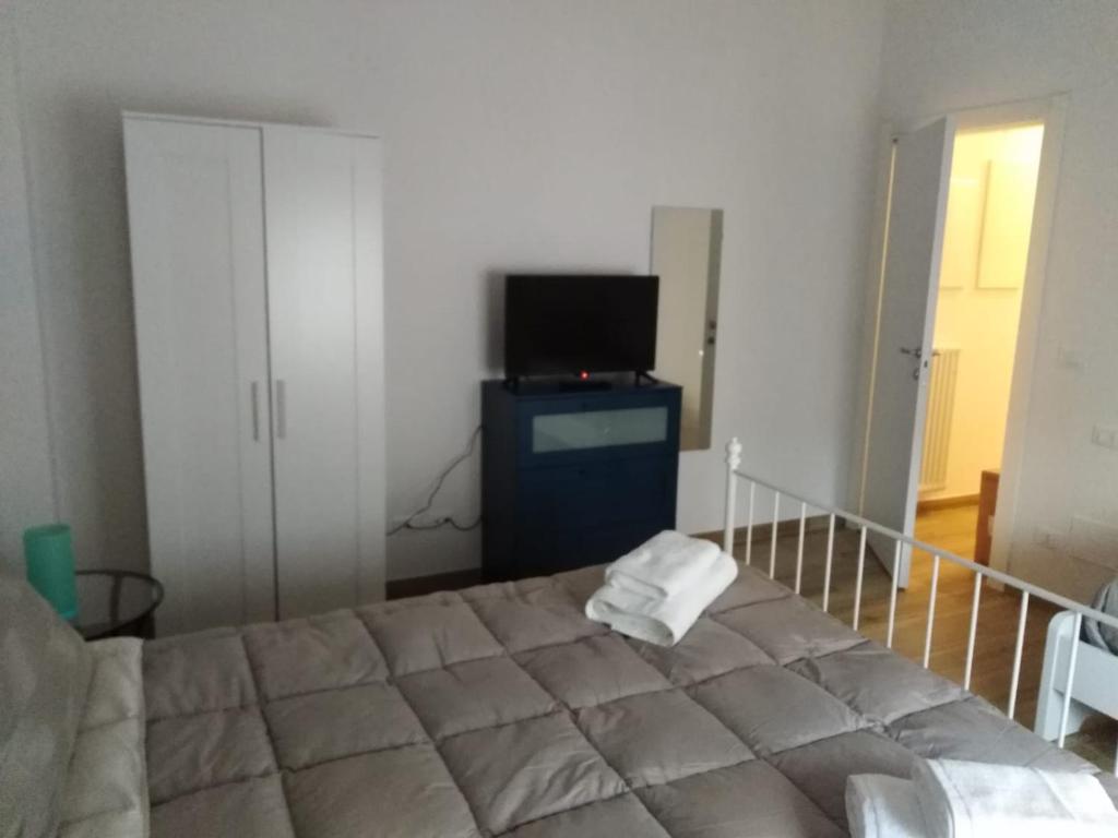 um quarto com uma cama, uma televisão e uma cama em FAMILY em Bolonha