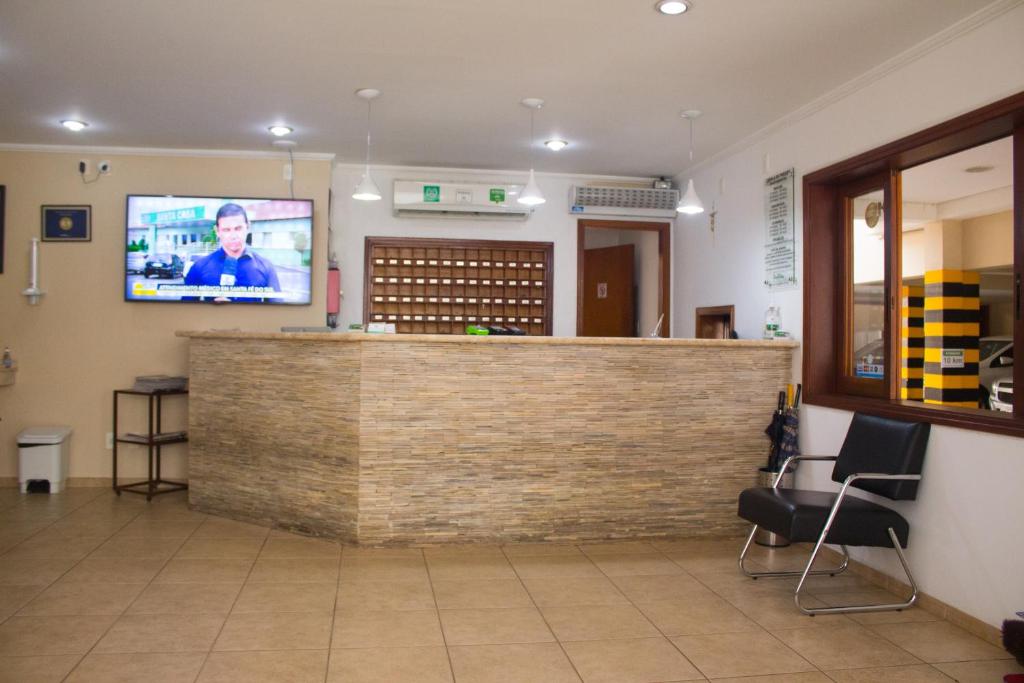 a bar in a waiting room with a tv on the wall at Hotel Garrafão - localizado no centro comercial de Boituva - SP in Boituva