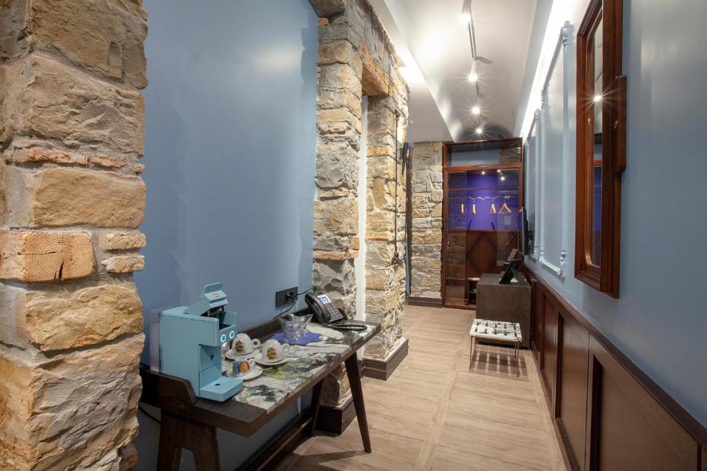 a hallway with a stone wall and a stone table at Hotel Solun in Trieste