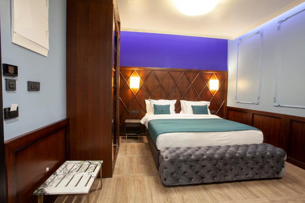 a bedroom with a bed and a bench in it at Hotel Solun in Trieste