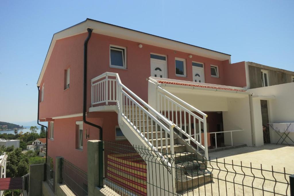 un edificio rojo con escaleras a un lado en Apartments Pehar, en Zaostrog