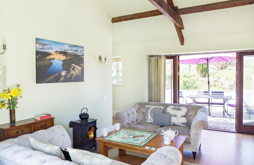 a living room with two couches and a table at The Neuadd Cottages in Crickhowell