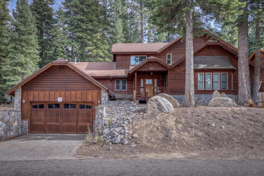 uma casa de madeira com garagem na floresta em Sweet Cherry Hills Escape em South Lake Tahoe