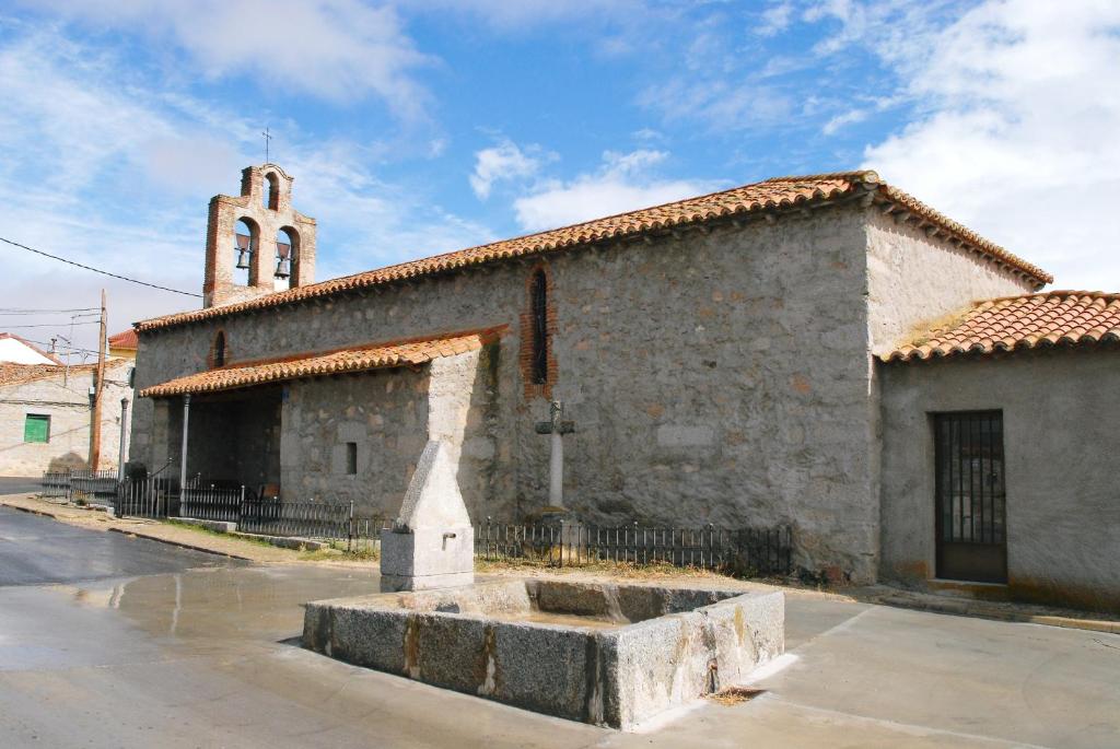 uma igreja com uma estátua em frente em Casa Monica em Narrillos de San Leonardo