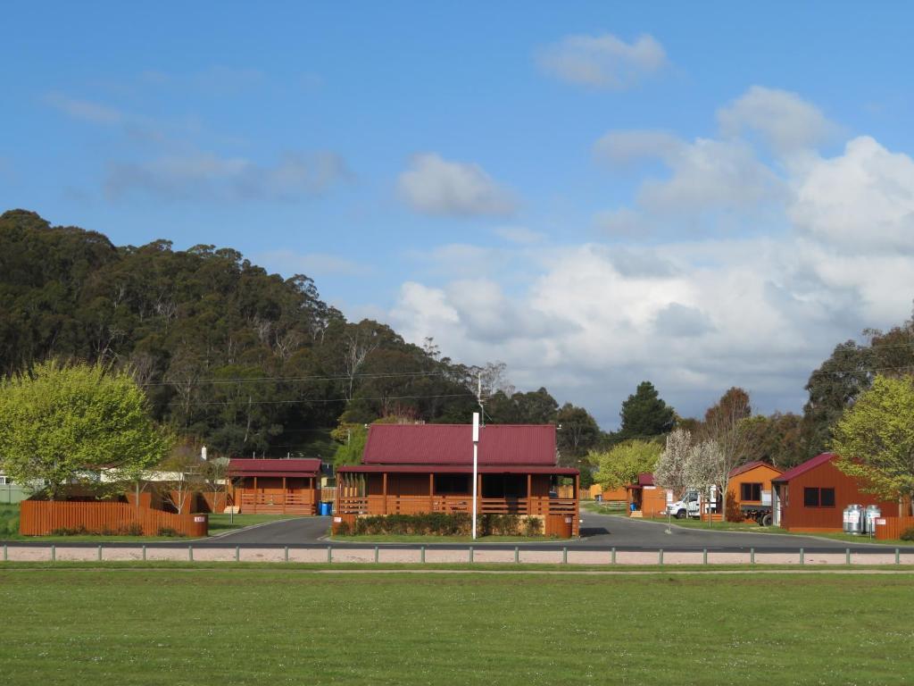 a building with a red roof on the side of a road at Latrobe Mersey River Cabin and Caravan Park in Latrobe