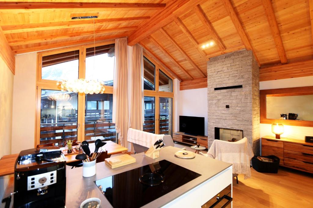 a living room with a table and a fireplace at Derby ski-in/out in Saas-Fee