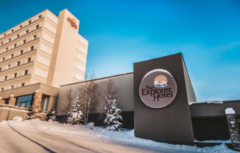 a hotel sign in the snow in front of a building at The Explorer Hotel in Yellowknife