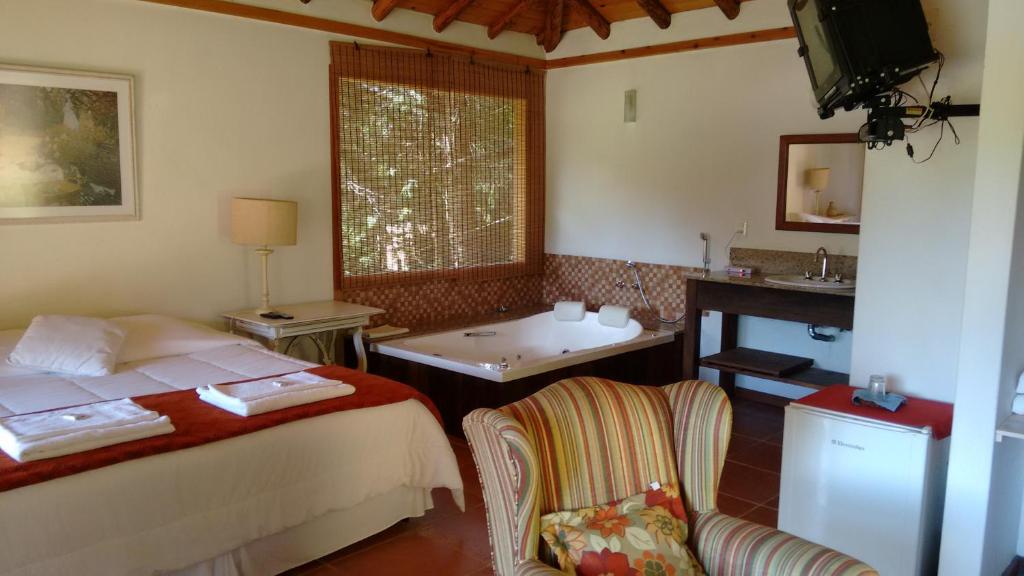 a bedroom with a bed and a sink and a mirror at Pousada Mariza in Nova Friburgo