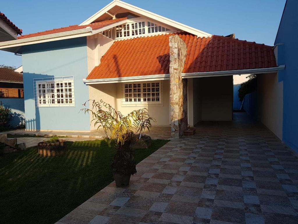 uma casa branca com um telhado laranja em Casa de praia em Guaratuba