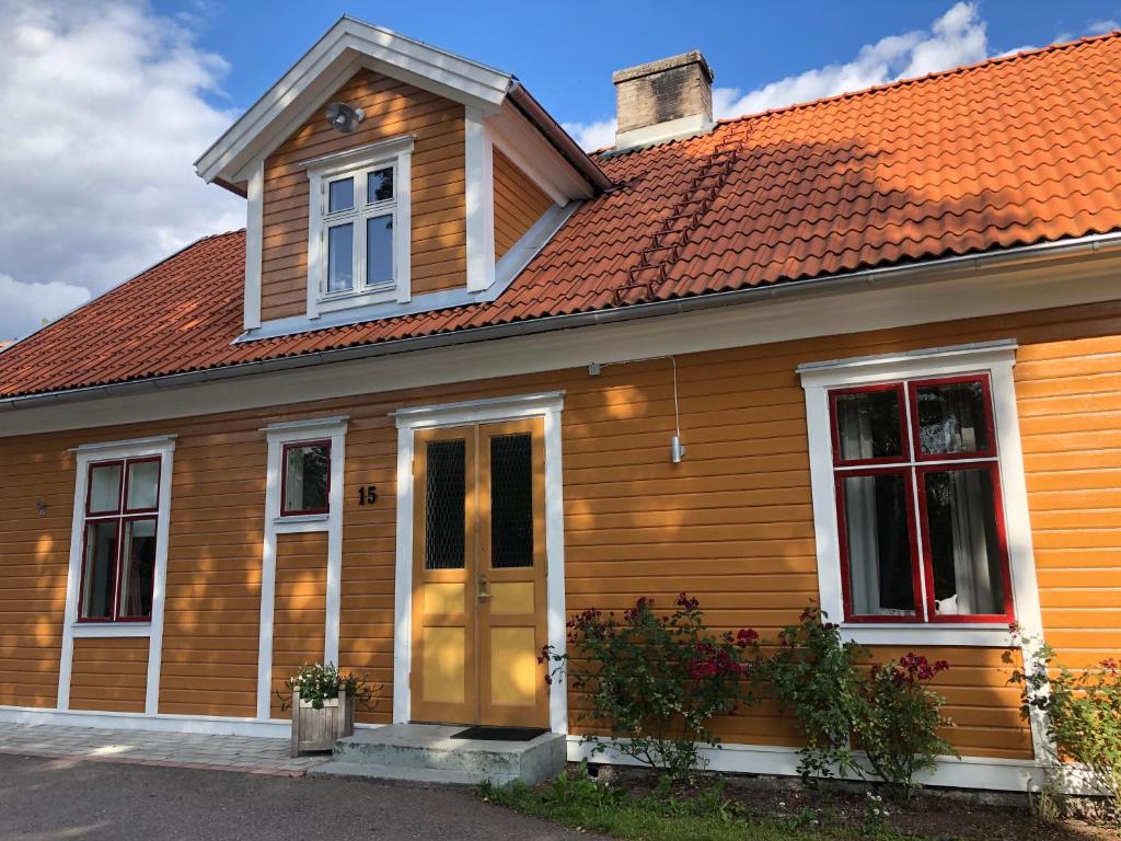 uma casa de madeira com um telhado laranja em Solbacka em Nybro