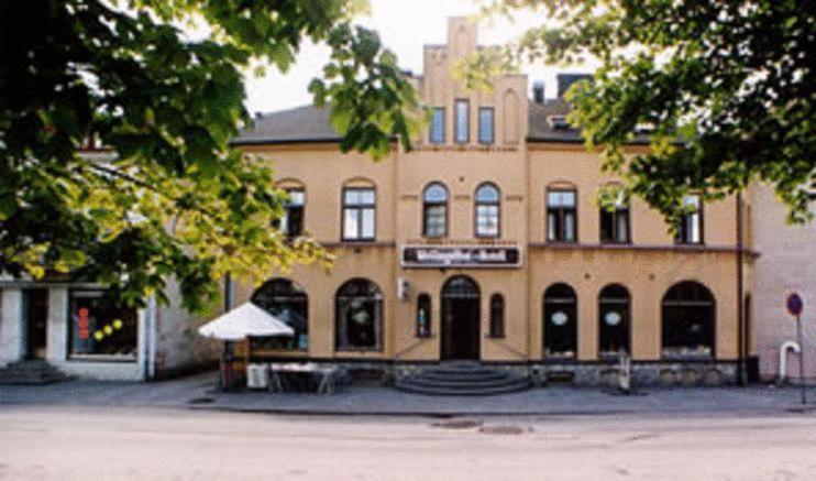 een groot bakstenen gebouw met een tafel ervoor bij Wellingehus Hotel in Vellinge