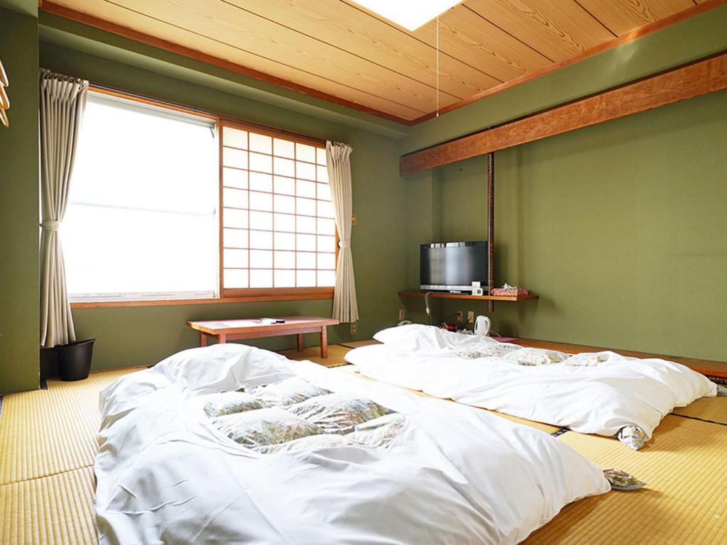 Un pat sau paturi într-o cameră la business ryokan haniwa