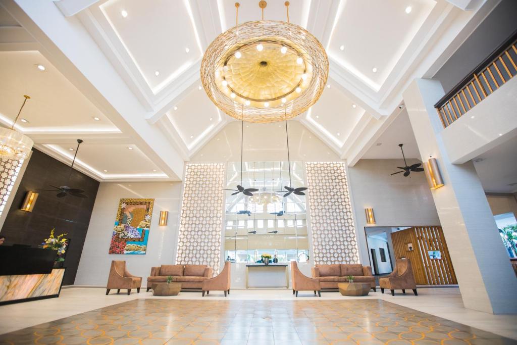 um grande átrio com um grande lustre e cadeiras em La Maja Rica Hotel em Tarlac