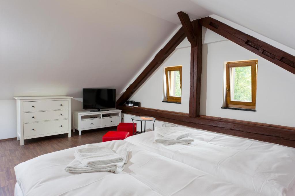 a bedroom with a white bed and a red chair at Havířská bouda in Kutná Hora