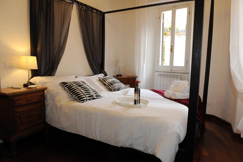 1 dormitorio con 1 cama blanca grande y ventana en Suite Lungara, en Roma