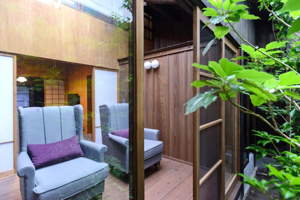 een paar stoelen op een houten terras bij Ayame-an in Kyoto