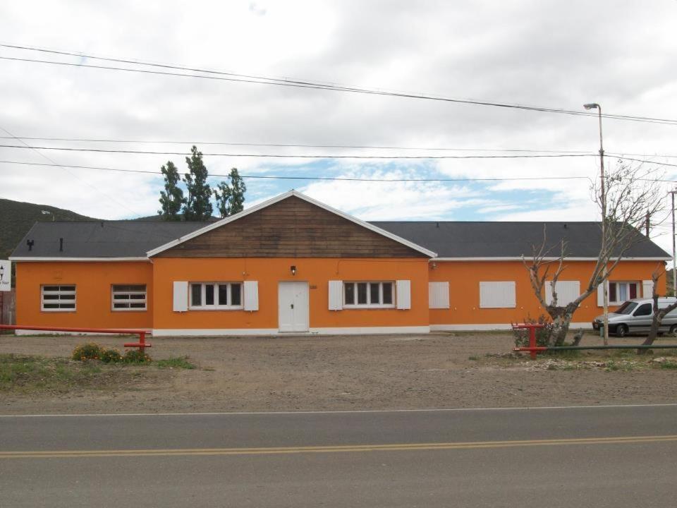 Un bâtiment orange avec une voiture garée devant. dans l'établissement Hospedaje Alva Suar, à Gasoducto