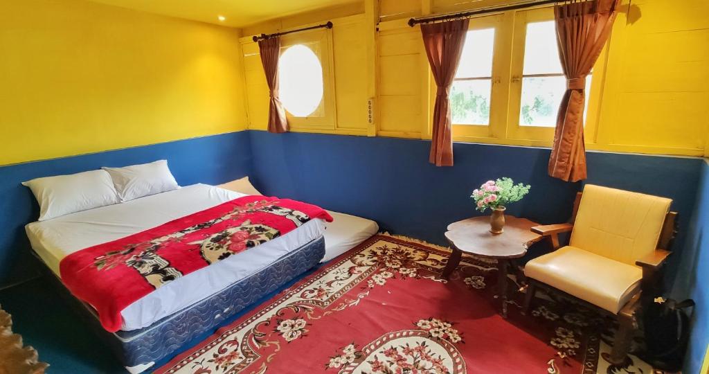 - une chambre avec un lit, une chaise et une table dans l'établissement The Cabin Bungalow, à Bedoyo