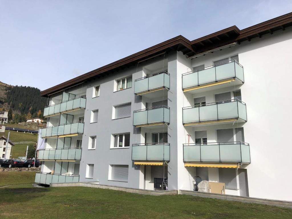 ein weißes Gebäude mit Balkon auf der Seite in der Unterkunft Ravaisch 22 in Davos