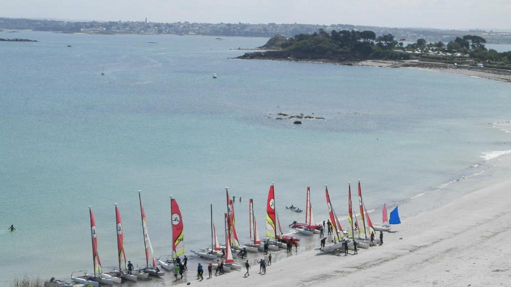 a group of sailboats on a beach next to the water at Location Tromeal Lasalle in Saint-Pol-de-Léon