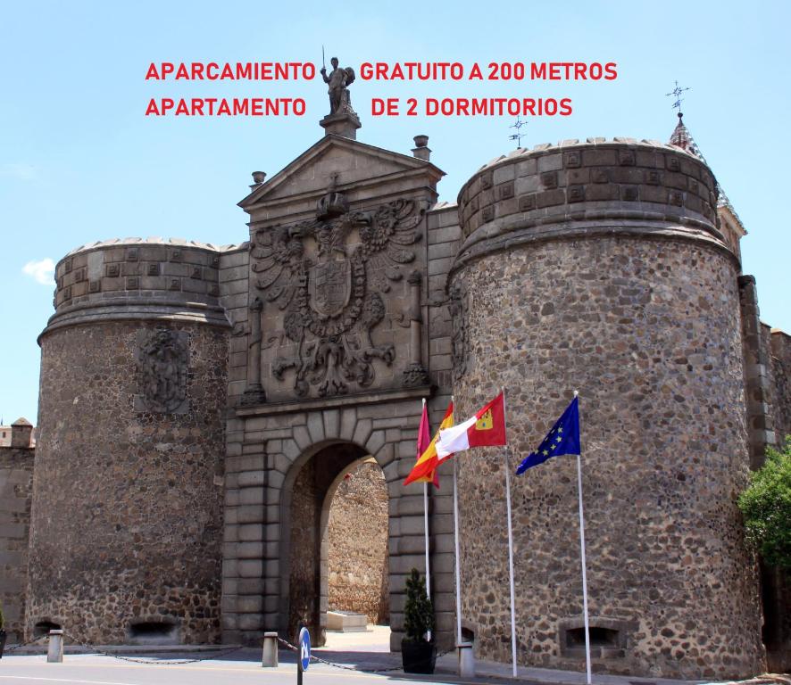 un castillo con dos banderas delante en Puerta de Bisagra- CON 2 HABITACIONES, en Toledo