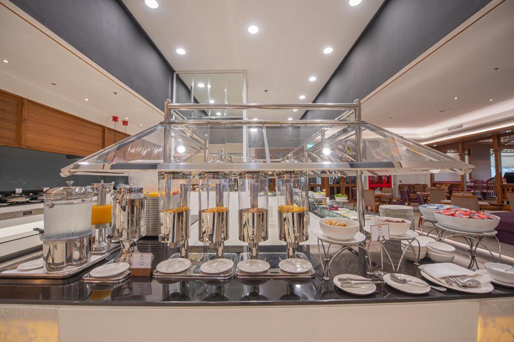 A covered buffet station displaying drinks, cereals, fruit, and serving dishes.