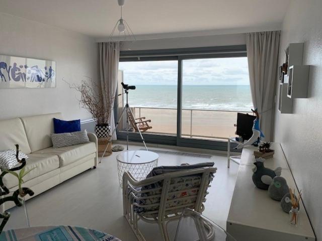 a living room with a view of the beach at Maya 804 in Nieuwpoort