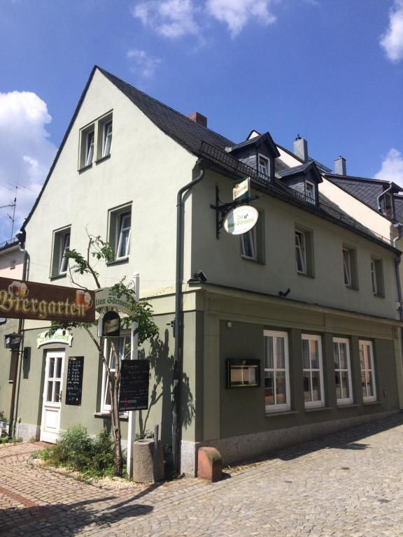 un gran edificio blanco con un cartel delante en PENSION zur alten Gärtnerei, en Reichenbach im Vogtland