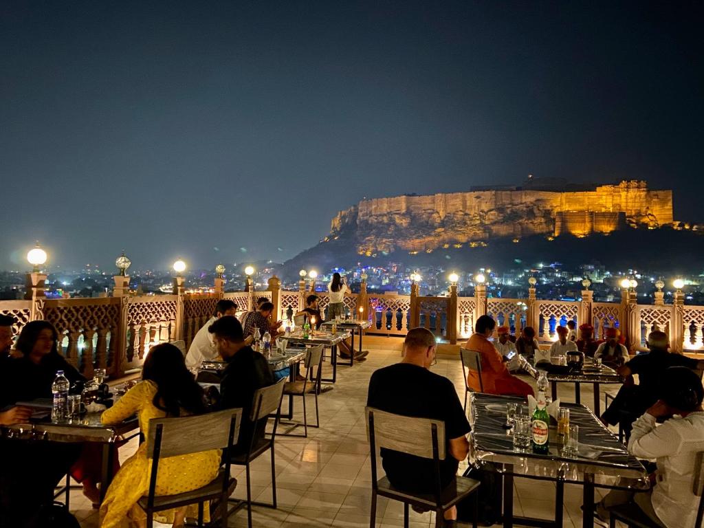a group of people sitting at tables on a patio at night at Kankariya Heritage in Jodhpur