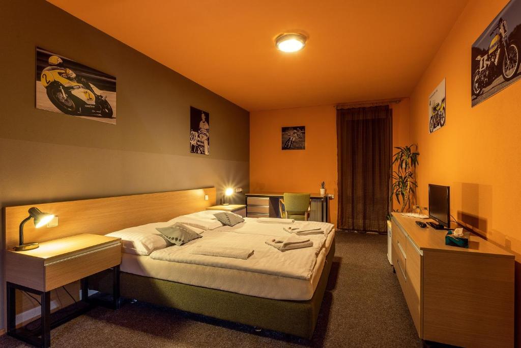 een slaapkamer met een bed, een bureau en een televisie bij Penzion ER1 in Zlín