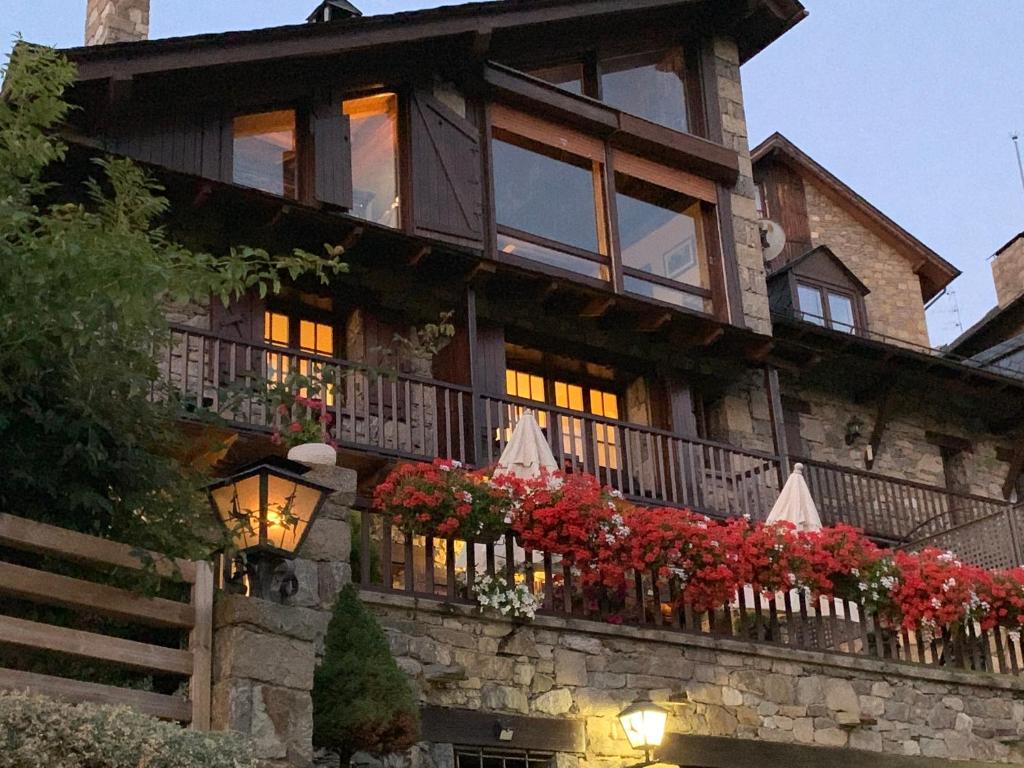 une grande maison fleurie sur un balcon dans l'établissement El Xalet de Taüll Hotel Rural, à Taull