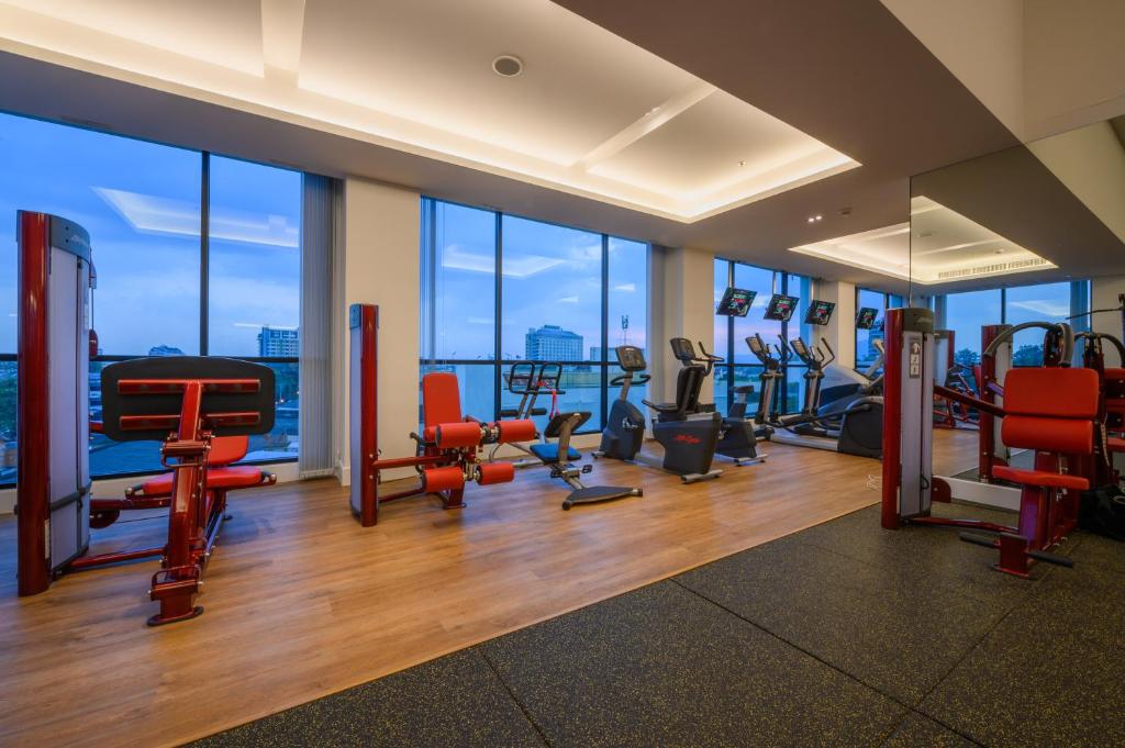 Cardio and resistance equipment sit in a windowed gym overlooking the city.