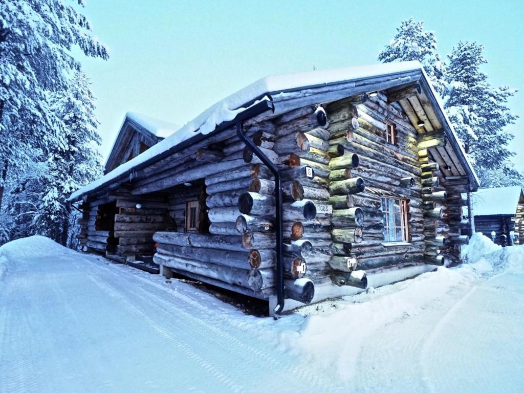 a log cabin with snow on the side of it at Levillas Martinmutka A & B in Levi