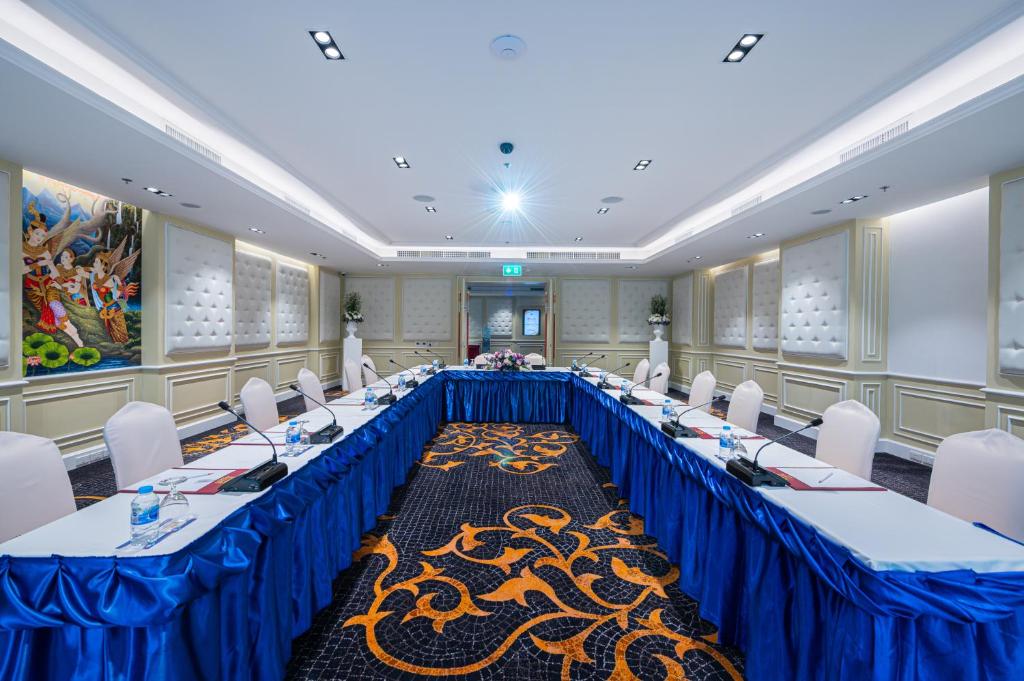 A boardroom-style conference setup with blue-draped tables.