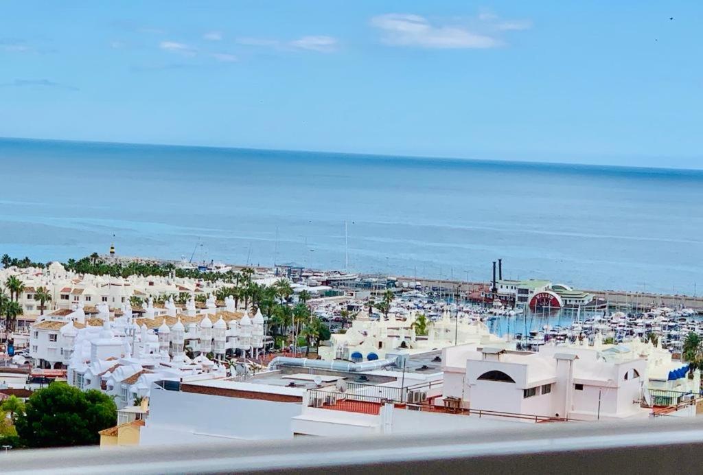 PUERTO MARINA BEACH TO 50m في مالقة: إطلالة على مدينة ذات مباني بيضاء وعلى المحيط