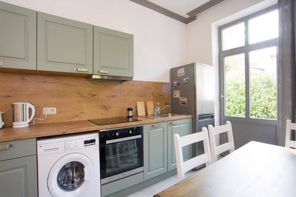 une cuisine avec un lave-linge et une table avec des chaises dans l'établissement Wohnung Eule im Haus Seeadler, à Zinnowitz