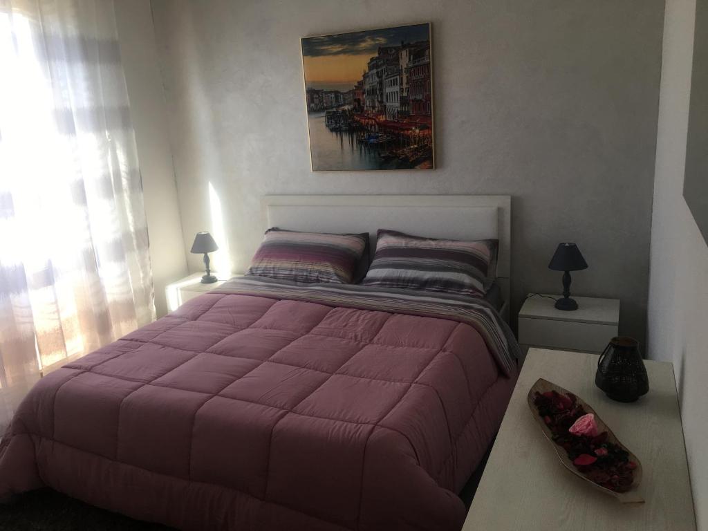 ein Schlafzimmer mit einem großen Bett mit einer lila Bettdecke in der Unterkunft Appartamento Francesca in Trapani