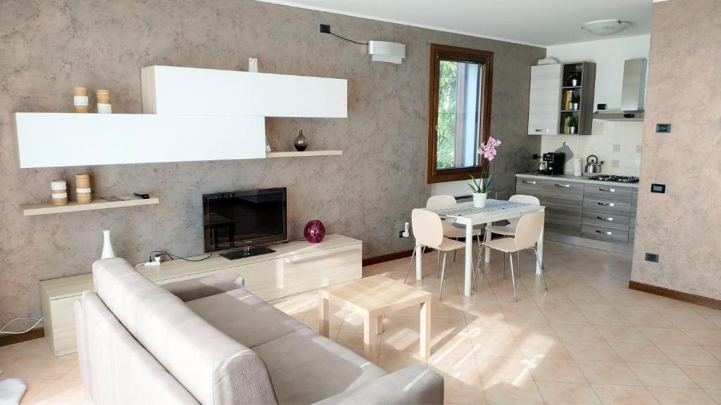 een woonkamer met een witte bank en een tafel bij Appartamento Ciesazza in Ponso