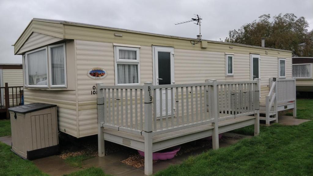 a tiny house with a porch on a yard at 8 Berth on The Chase (ABI) in Ingoldmells