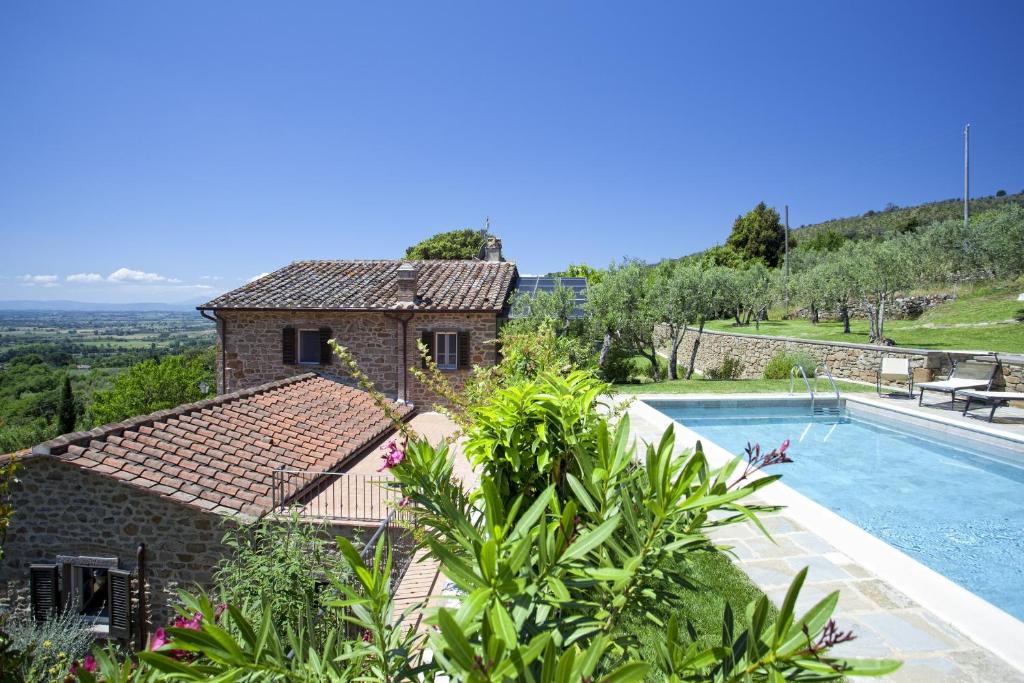 a villa with a swimming pool and a house at Villa San Pietro in Cortona