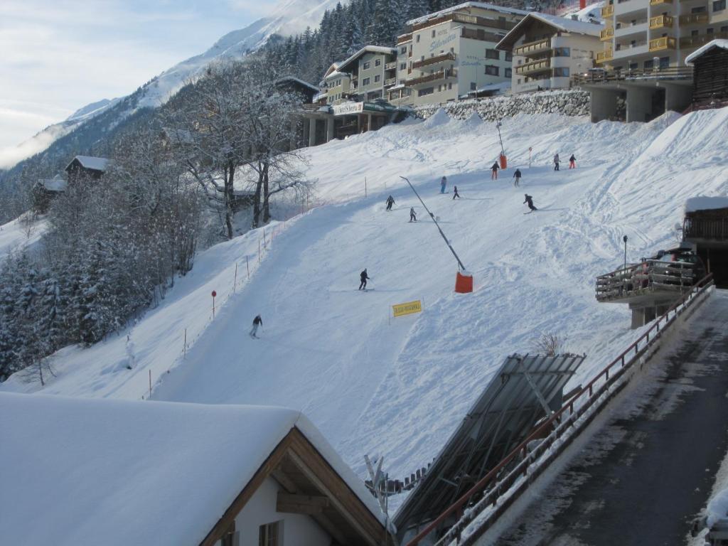 eine Gruppe von Personen, die auf einer schneebedeckten Piste Ski fahren in der Unterkunft Haus Arosa in Kappl