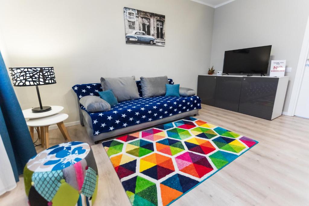 een woonkamer met een bank en een kleurrijk tapijt bij Travel Homzzz Central Apartments - Tusnad in Târgu-Mureş