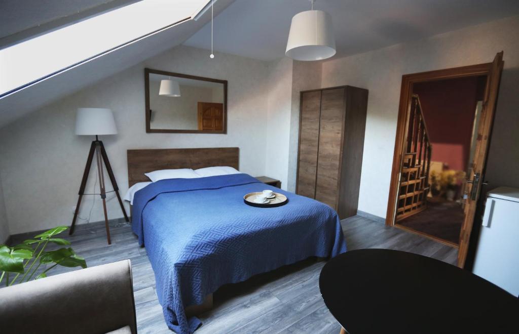 una camera con un letto e una coperta blu di Pas Juste a Nida