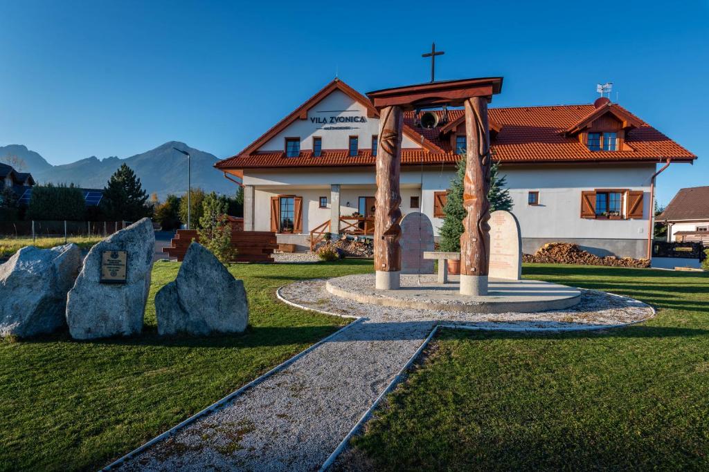 ein Gebäude mit einem Garten mit Felsen davor in der Unterkunft Vila Zvonica in Starý Smokovec