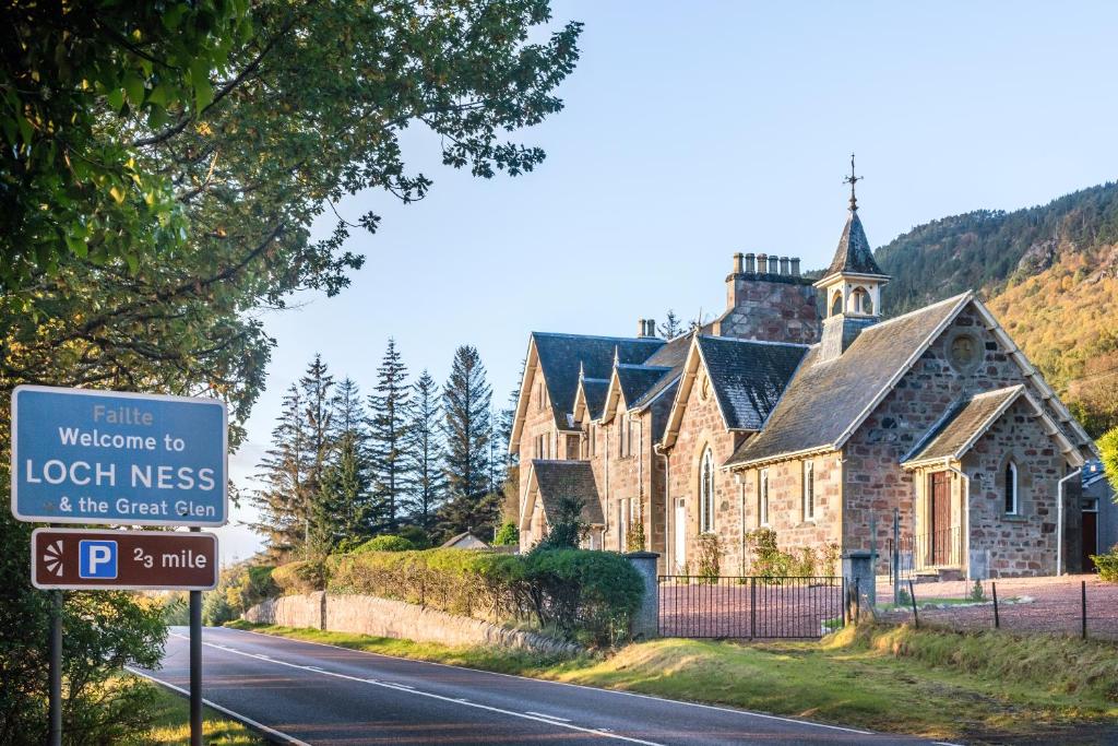 a church on the side of a road with a sign at The Old Manse, Loch Ness (highland-escape) in Inverness