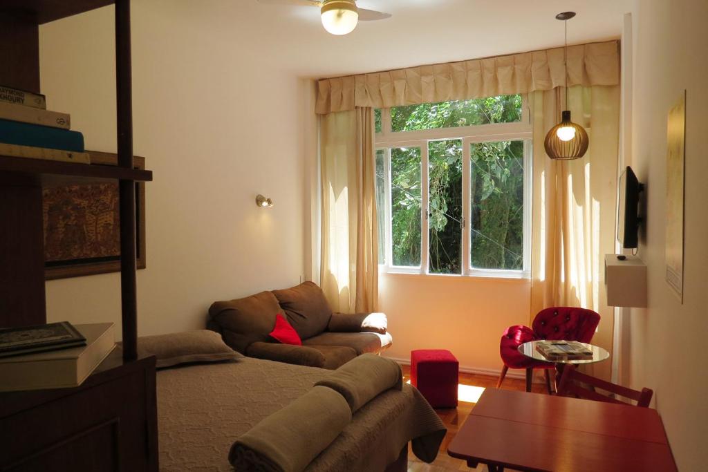 een woonkamer met een bank en een raam bij Studio 14 in Petrópolis