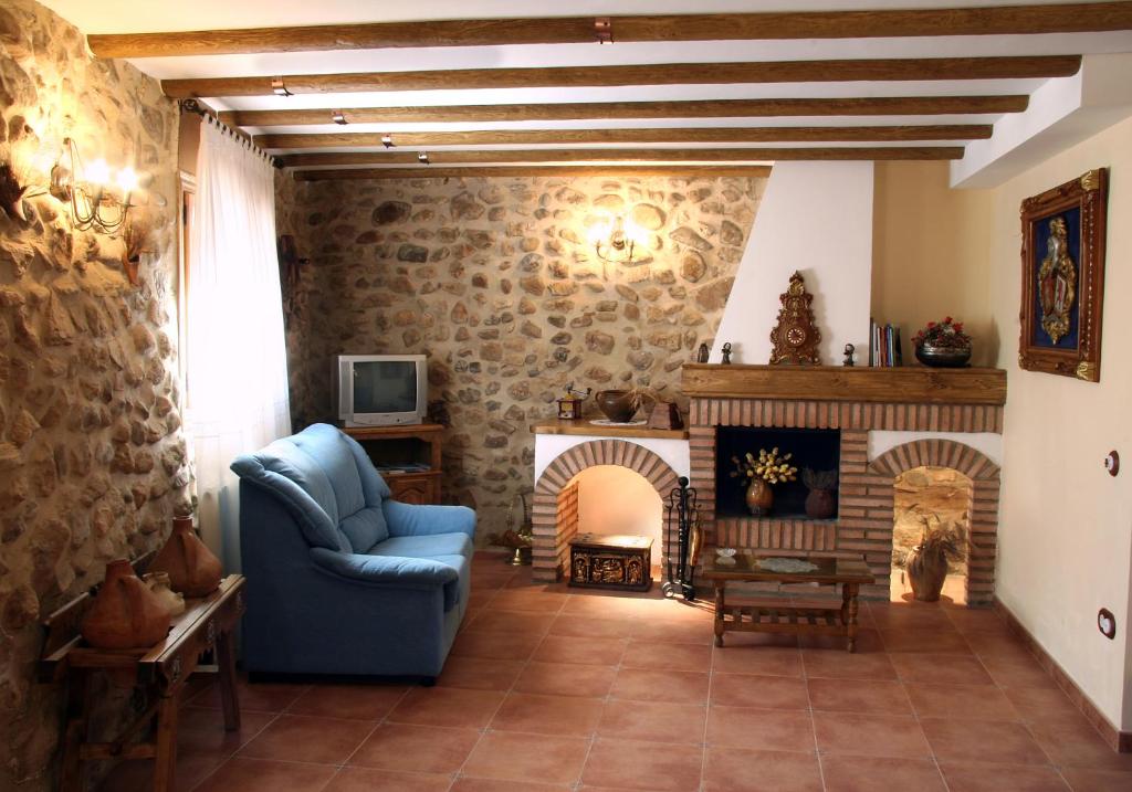 a living room with a blue chair and a fireplace at LA PORTAZA in Vera de Moncayo