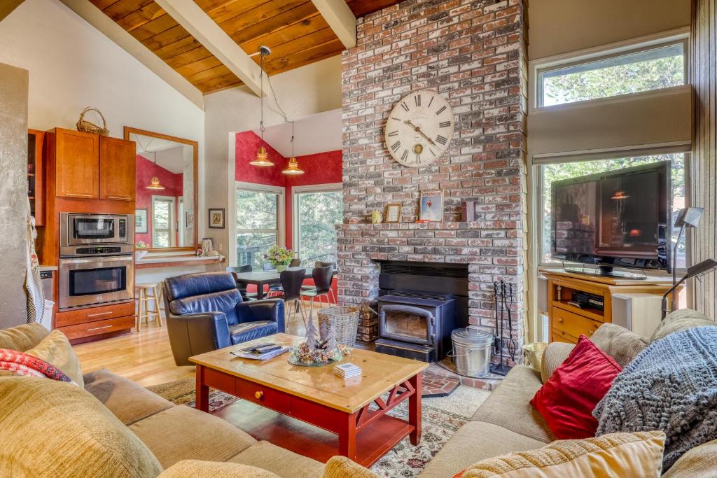 a living room with a brick fireplace with a clock at Chamonix 85 in Mammoth Lakes