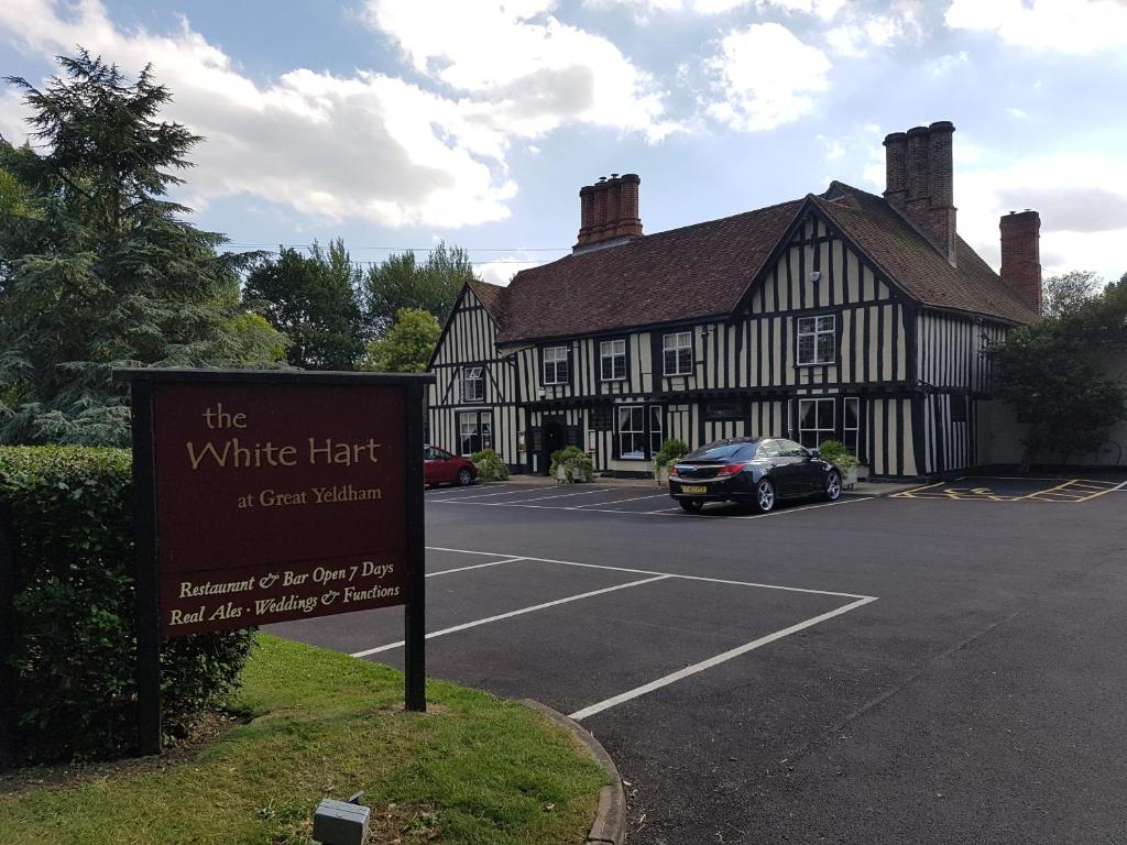 a sign in front of a black and white building at The White Hart in Great Yeldham