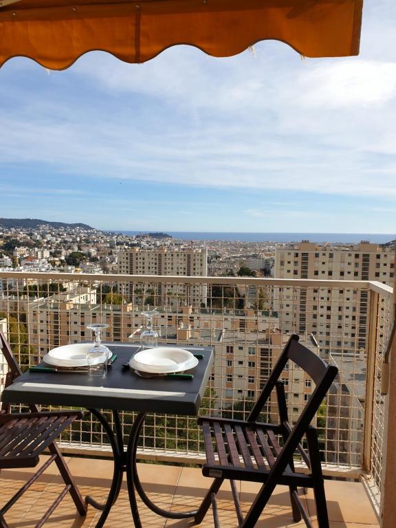 a table and chairs on a balcony with a view at Le Panoramique in Nice